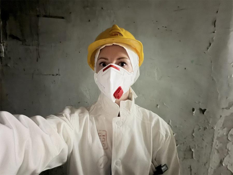 Tchernobyl (Ukraine) : notre journaliste Oksana Rekun en combinaison de protection, masque et casque sur la tête.