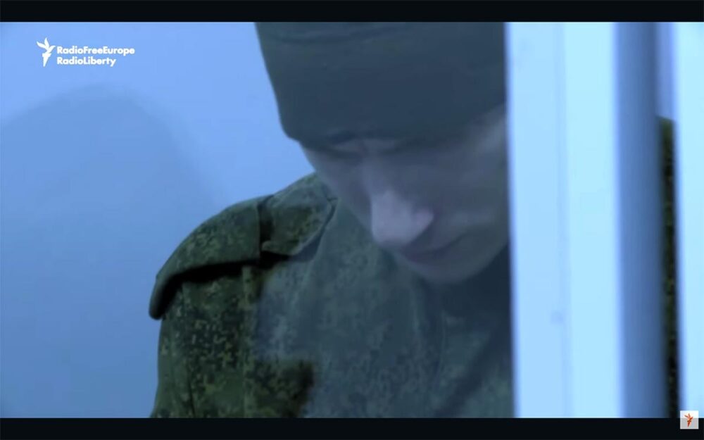 Dmitriy Kurashov, un soldat russe, a été condamné à la prison à vie en Ukraine pour avoir exécuté un soldat ukrainien désarmé. Image (capture vidéo) : Kurashov baisse la tête, dans le box des accusés lors de son procès.