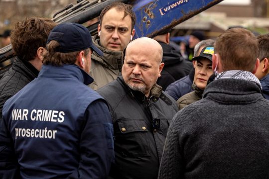 Karim Khan, the prosecutor of the International Criminal Court (ICC), is visiting Bucha (Ukraine) with Iryna Venediktova. On the back of a person accompanying them, one can read "War crimes prosecutor".