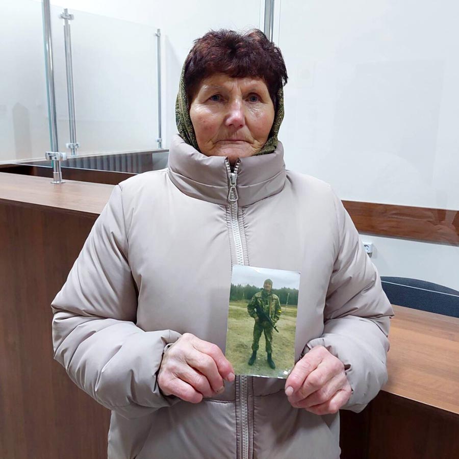 Une femme tient une photo de son fils (Roman Pyuryk), soldat ukrainien tué dans une attaque de missile.