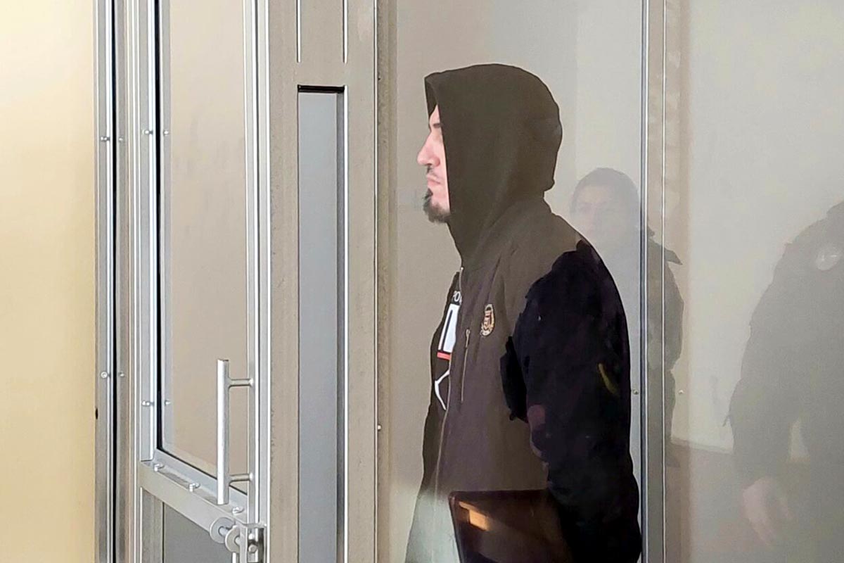 Ruslan Glotov (habillé tout en noir, capuche sur la tête) est dans le box des accusés lors de son procès en 2022.