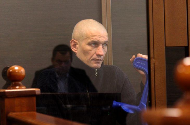 Ruslan Yelkin, a separatist fighter accused of treason in Ukraine, sits during his trial in Odessa. He holds a crutch in his hand.