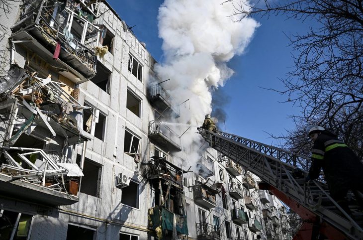 Des pompiers ukrainiens tentent d'éteindre l'incendie d'un bâtiment civil suite à un bombardement russe.
