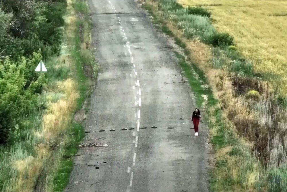 Валерія Богомаз йде слідом за дроном, який вказує їй напрямок до українських військових у червні 2022 року в Харківській області (скріншот з фільму «Йди за мною»).