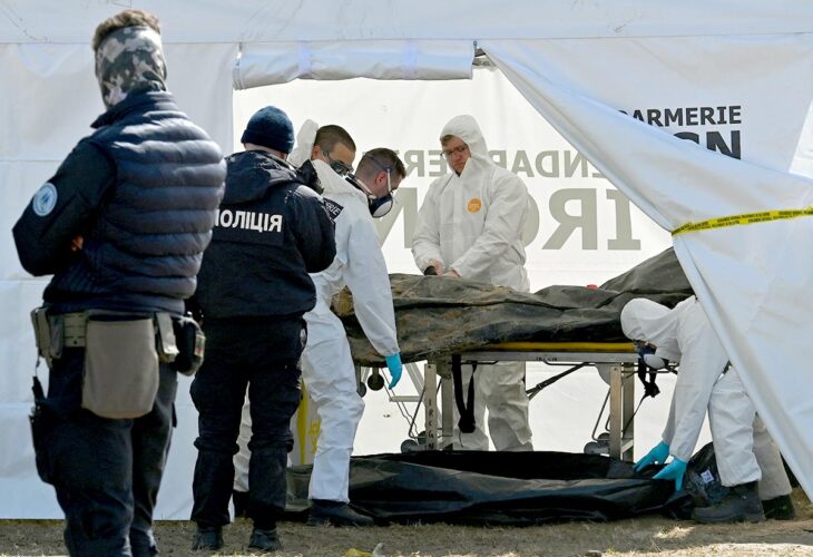 War crimes in Ukraine - Investigators from the French Gendarmerie's Institute of Criminal Research (IRCGN) examine a body in a tent after its exhumation from a mass grave in Bucha, in cooperation with Ukrainian police.