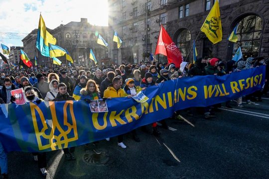 Des manifestants tiennent une banderolle où il est écrit "Ukrainians will resist"