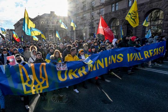 Protesters hold a banner that reads "Ukrainians will resist"