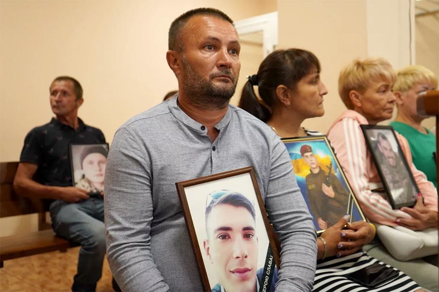 At the trial of prosecutor Gennadyi Herman, the father of a Ukrainian soldier killed during the bombing of the Mykolaïv barracks, holds a photo of his son.