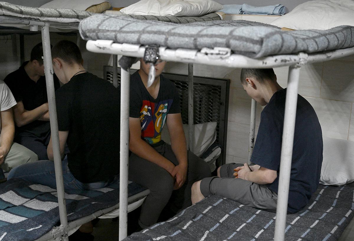 Russian prisoners of war sit on bunk beds in a detention camp in Ukraine.