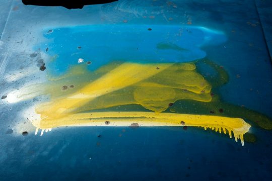 Un « Z » (symbole de l’invasion militaire russe en Ukraine) est peint en blanc sur le capot d’une voiture puis repeint aux couleurs du drapeau ukrainien (jaune et bleu).
