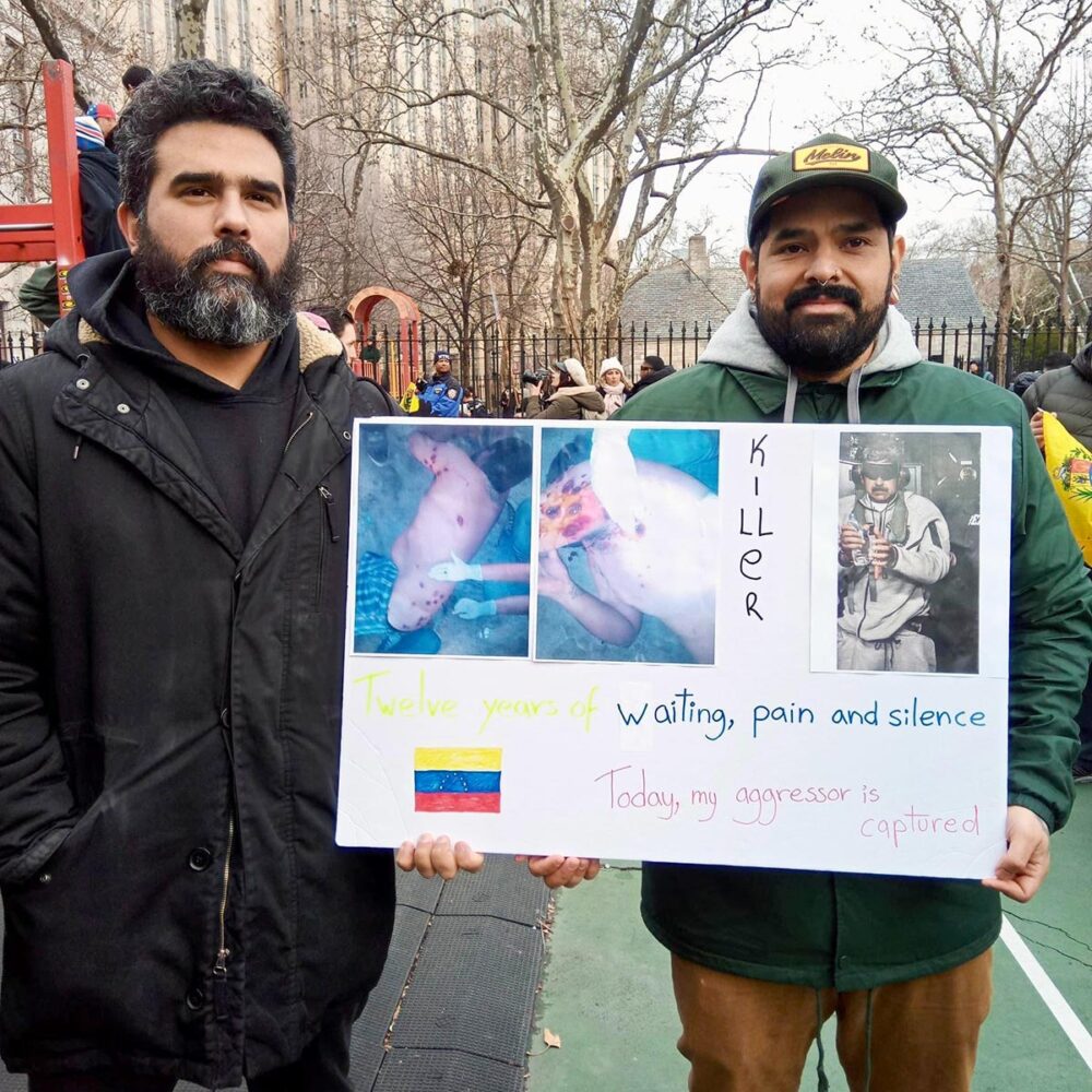 A New-York (USA), Pedro Reyes, qui affirme avoir été victime des violences sous le régime de Nicolás Maduro, tient une pancarte montrant les blessures qu'il aurait subies. Il est accompagné par Javier, qui é également fui le Venezuela pour rejoindre les Etats-Unis.