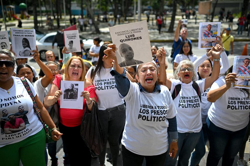 What justice for Venezuela? Photo: Protesters hold up photos of their relatives, who are political prisoners, in the street.