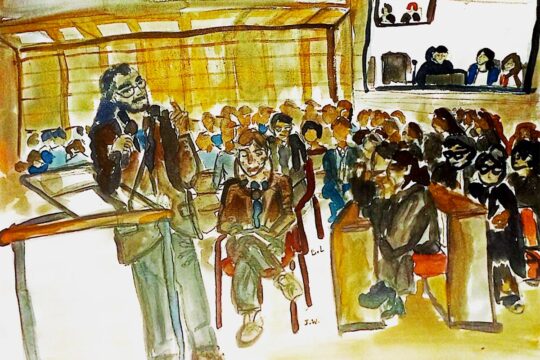 Procès Lafarge à Paris (France) pour des crimes allégués en Syrie incluant des flux financiers vers des organisations terroristes. Illustration : peinture (aquarelle) représentant la salle d'audience où l'on voit une personne debout à la barre et une autre assise à côté, des écouteurs sur les oreilles.