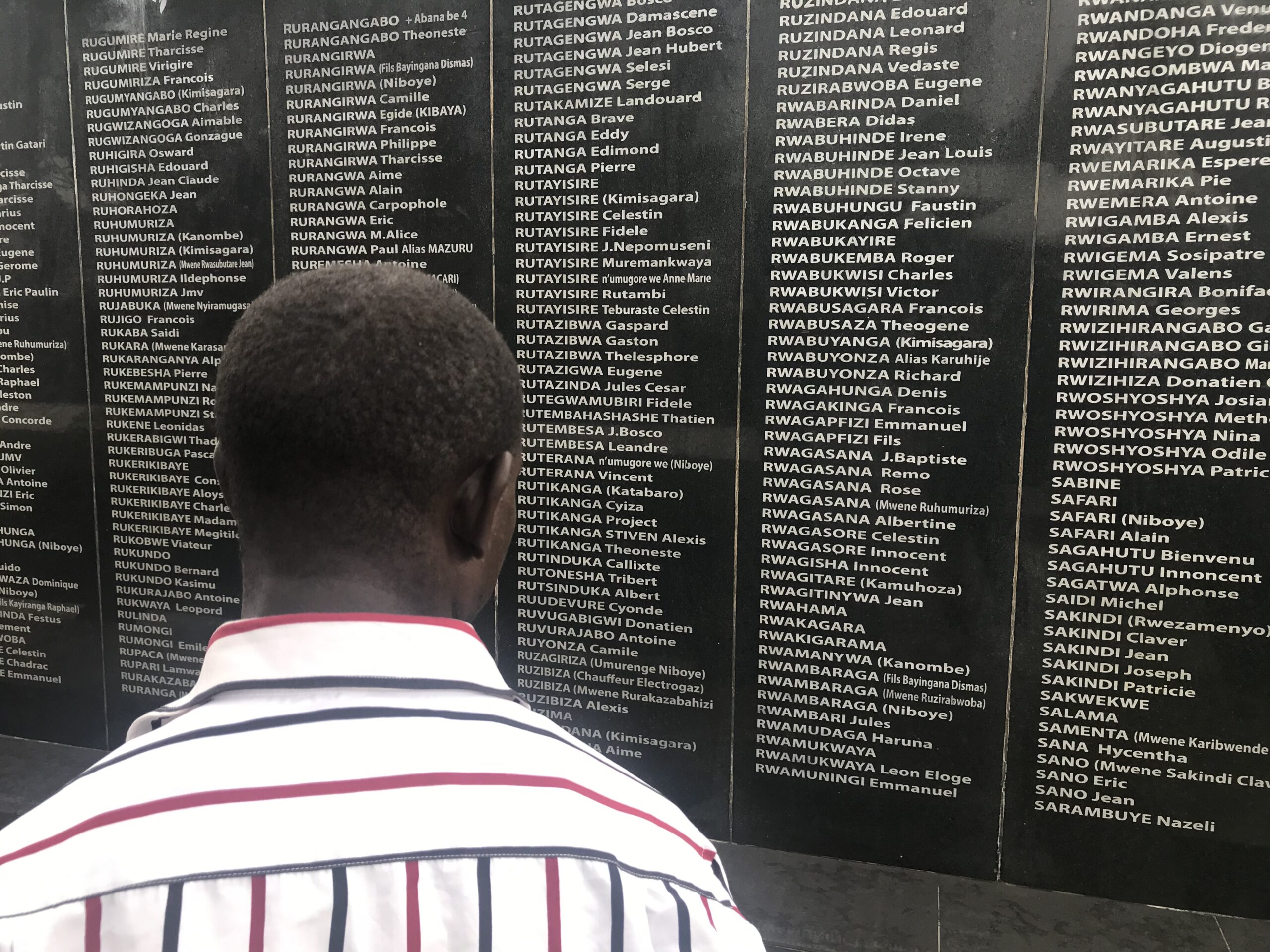 Un homme scrute les noms de victimes du génocide au mémorial du mont Rebero, à Kigali.