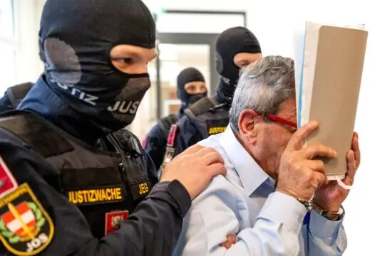 Syria: Former Syrian general Khaled al-Halabi has been convicted in Austria on allegations of torture, under the principle of universal jurisdiction. Photo: Halabi is escorted by Austrian police officers and is covering his face.