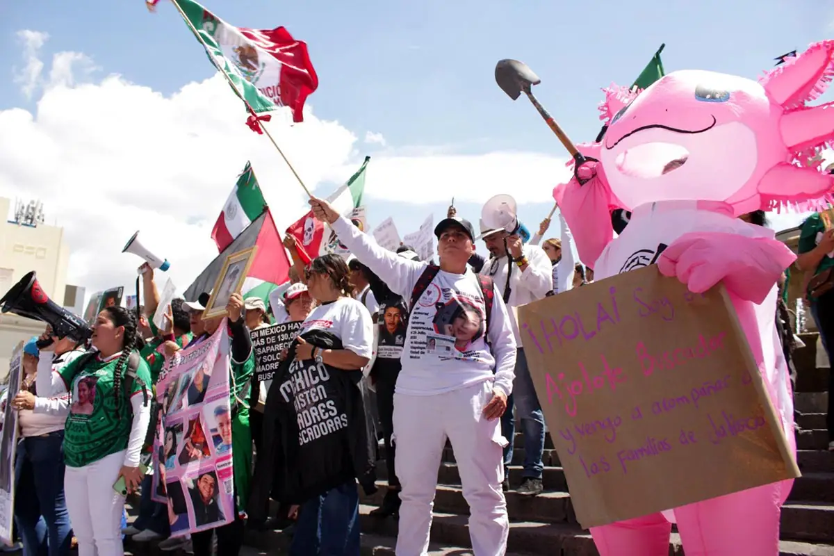 In Mexico, families are protesting near the World Cup football stadiums to draw attention to the many cases of enforced disappearances in the country. Photo: several people (some of whom are in fancy dress) are waving Mexican flags and holding shovels, whilst others are displaying photos of missing persons.